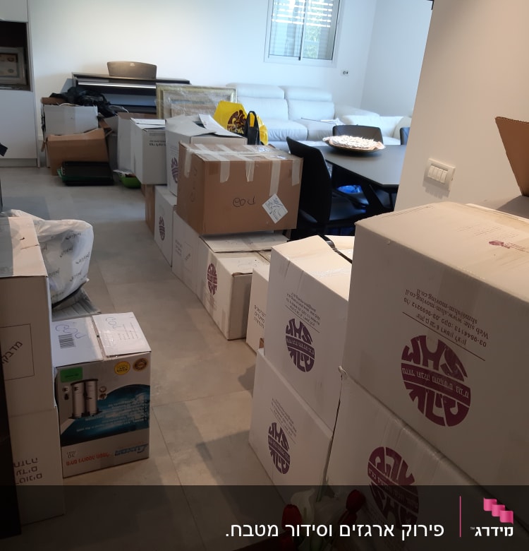 קופסאות קרטון מסודרות בחדר עם פרחים אדומים